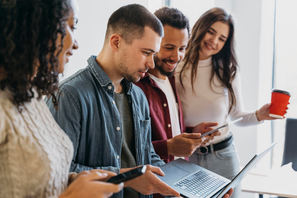Equipe reunida em frente a um notebook, discutindo os erros em release para criar um comunicado eficaz e alinhado com a estratégia de comunicação.