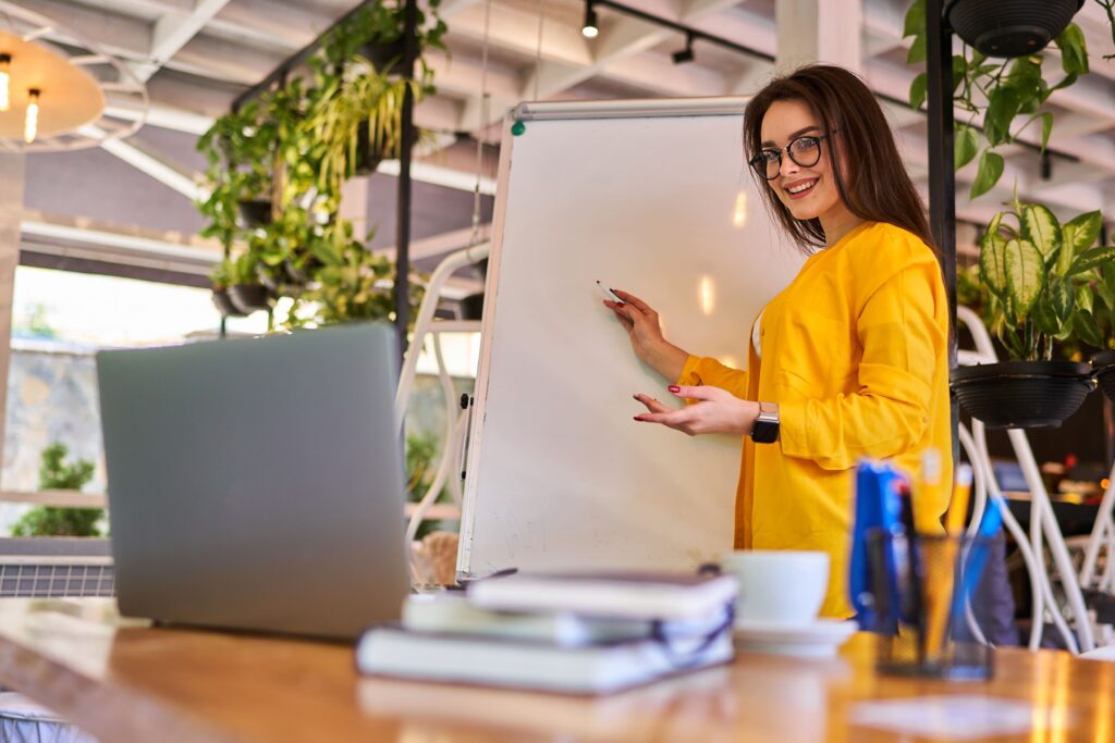 Profissional de comunicação orientando cliente em uma simulação de entrevista, demonstrando técnicas de postura e linguagem corporal para preparar clientes para entrevistas com confiança e clareza.