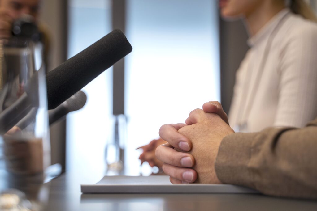 Momento de entrevista com jornalista e porta-voz, evidenciando a aplicação prática das técnicas para preparar o porta-voz a comunicar-se com assertividade.